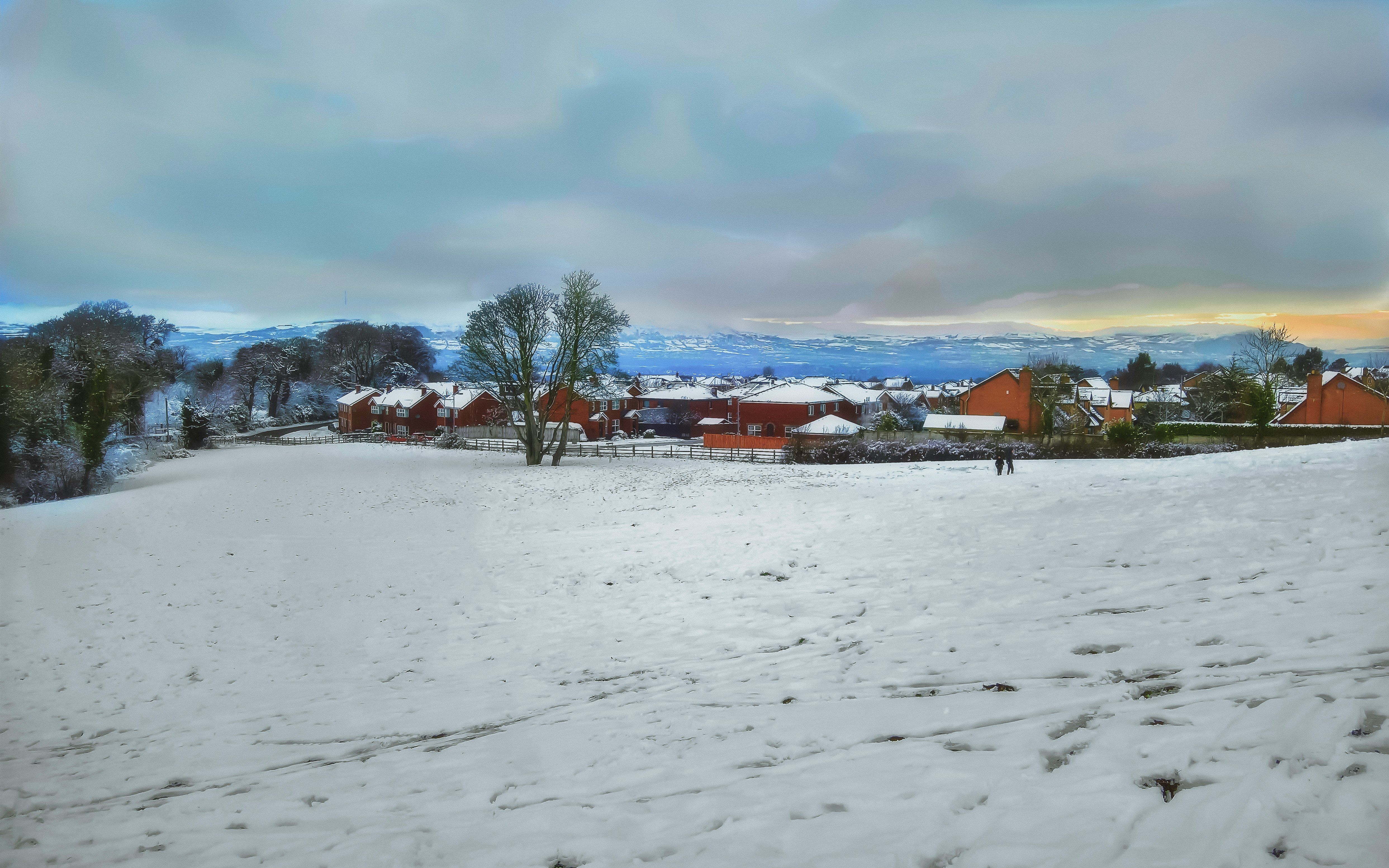 houses on snow covered field under cloudy sky during daytime